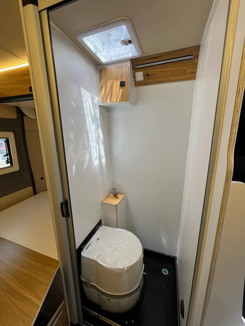 Potti escamoteable sobre guías en el baño de la camperización del Ducato L2H2