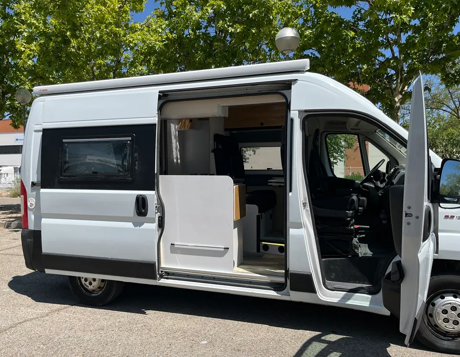 Furgoneta camper Ducato L2H2 con la puerta corredera abierta y la cocina a la vista