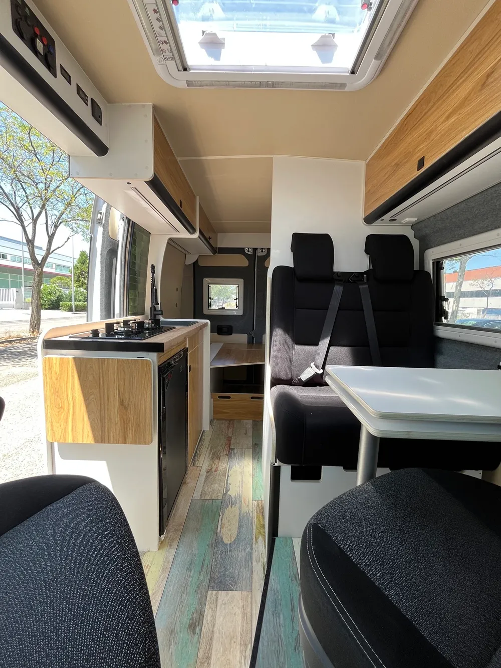 Salón de la camper Ducato L2H2 con mesa abatible y asientos delanteros giratorios