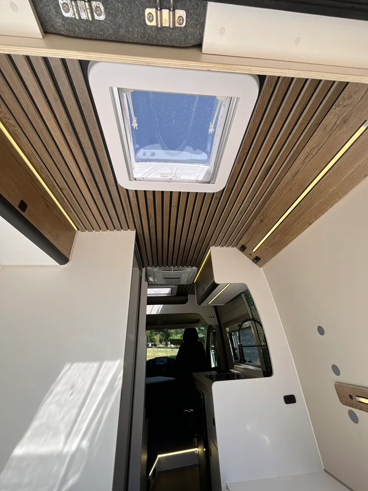 Claraboya abierta y techo de lamas de madera con tiras LED en la camper Jumper L2H2