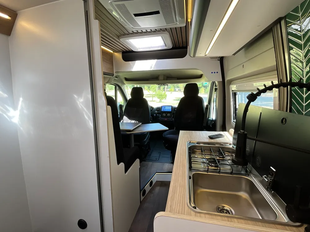 Cocina con fregadero y fogones de la camper Jumper L2H2 mirando hacia la cabina
