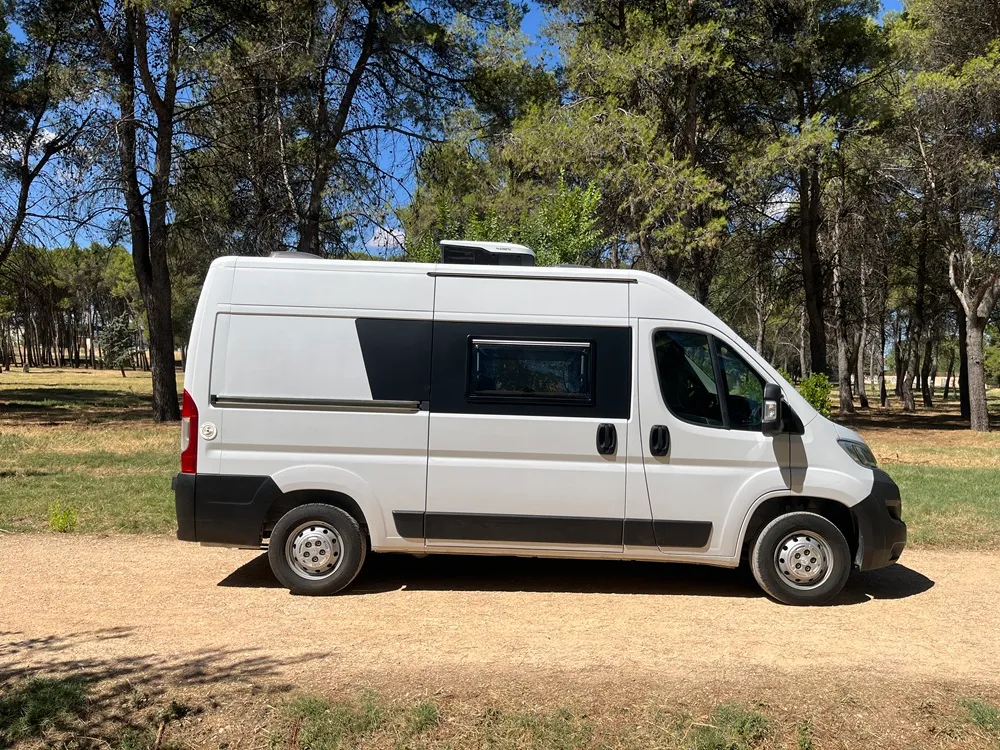 Lateral completo de la furgoneta camper Citroën Jumper L2H2 con aire acondicionado en el techo