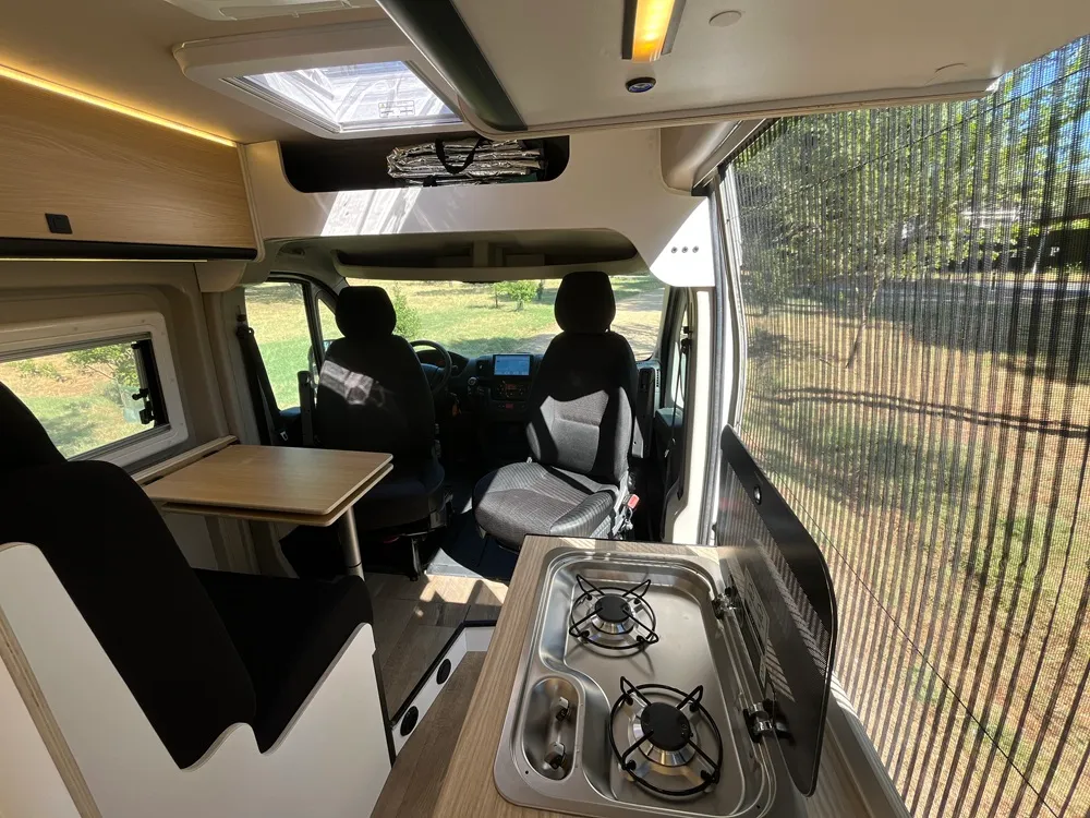 Cocina de dos fogones a gas y salón de cuatro plazas de la camper Opel Movano L3H2