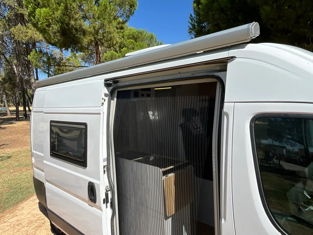 Mosquitera plisada montada en la puerta corredera de la furgoneta camper Movano L3H2