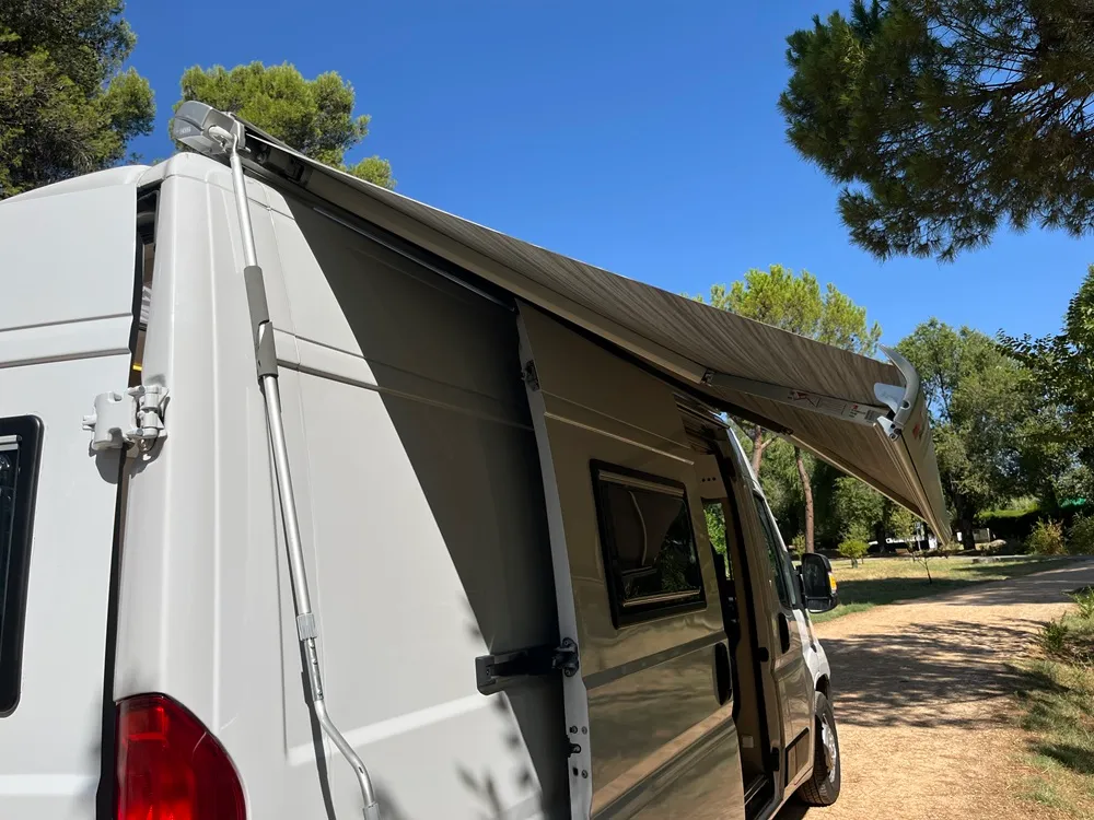Detalle del toldo Fiamma F80s extendido sobre la puerta corredera de la camper Movano